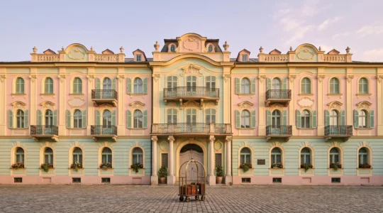 Façade symétrique aux tons pastel évoquant l'esthétique nostalgique et artificielle de Wes Anderson