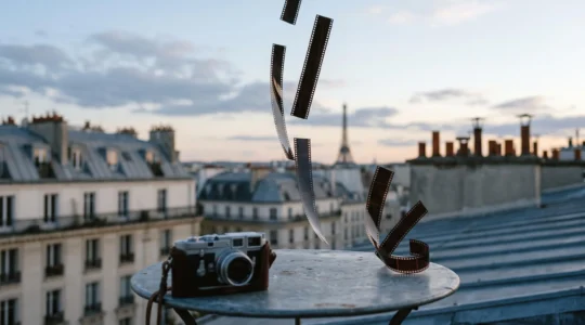 Fragments de pellicule argentique suspendus évoquant la rupture temporelle du jump cut, dans un décor parisien inspiré de la Nouvelle Vague
